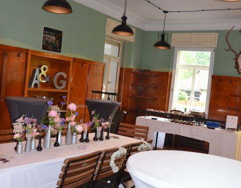 Auf dem Foto ist ein Raum zu sehen, der im Vintage-Look gestaltet ist. Im Hintegrund ist ein Buffet mit Essen zu sehen.